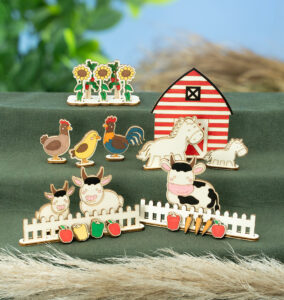 Fargerike trefigurer med gårdsmotiv viser dyr, låve, blomster og grønnsaker.