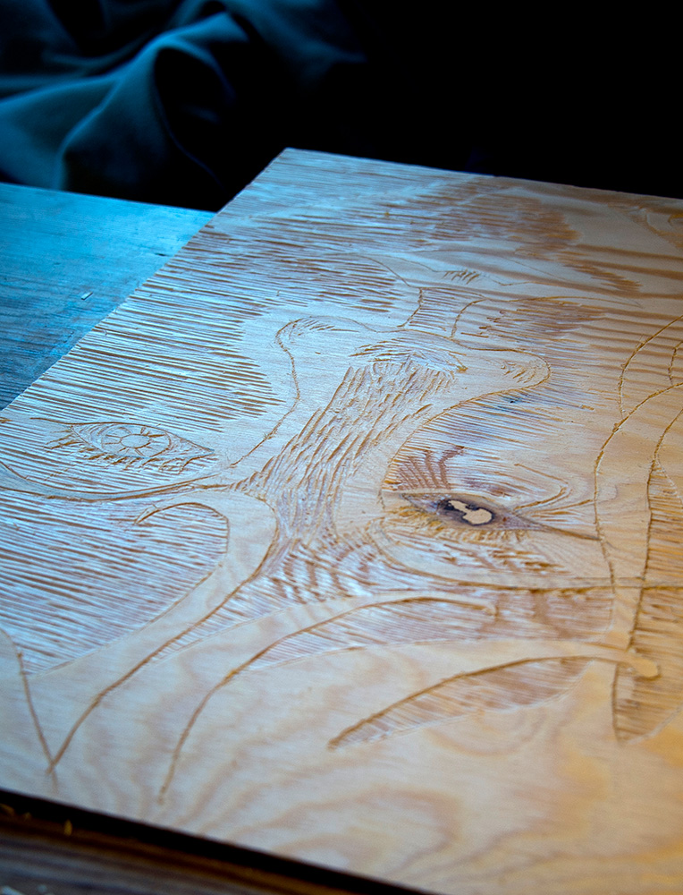 Utskjært tresnittplate med synlige linjer og årringer på et bord.