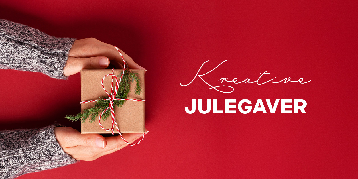 Hender i strikkegenser holder en liten gave pakket i brun papir med rød-hvit snor.