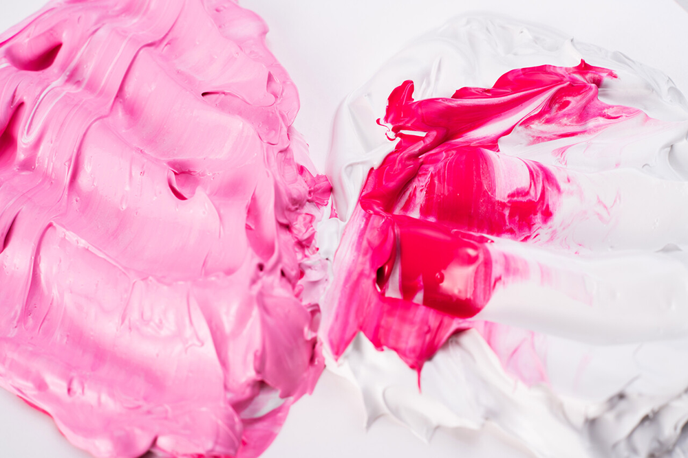 Tykk modellpasta i rosa og hvitt med synlige strøk og tekstur på hvit bakgrunn.