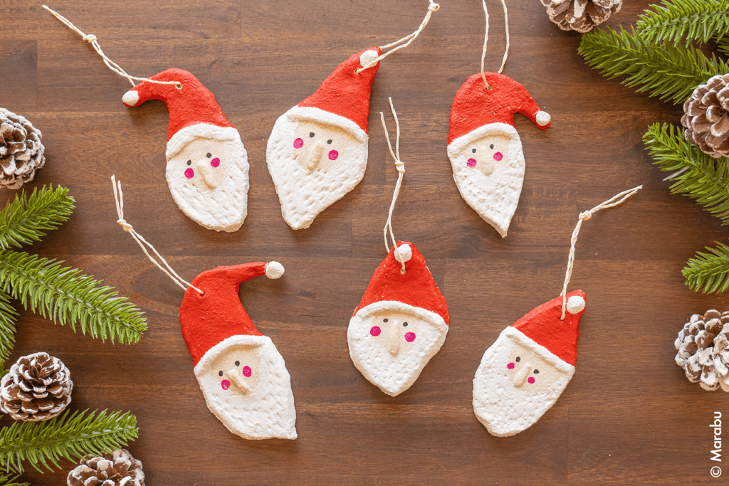 Seks nissefigurer i trolldeig med snor, lagt flatt på trebord sett ovenfra.
