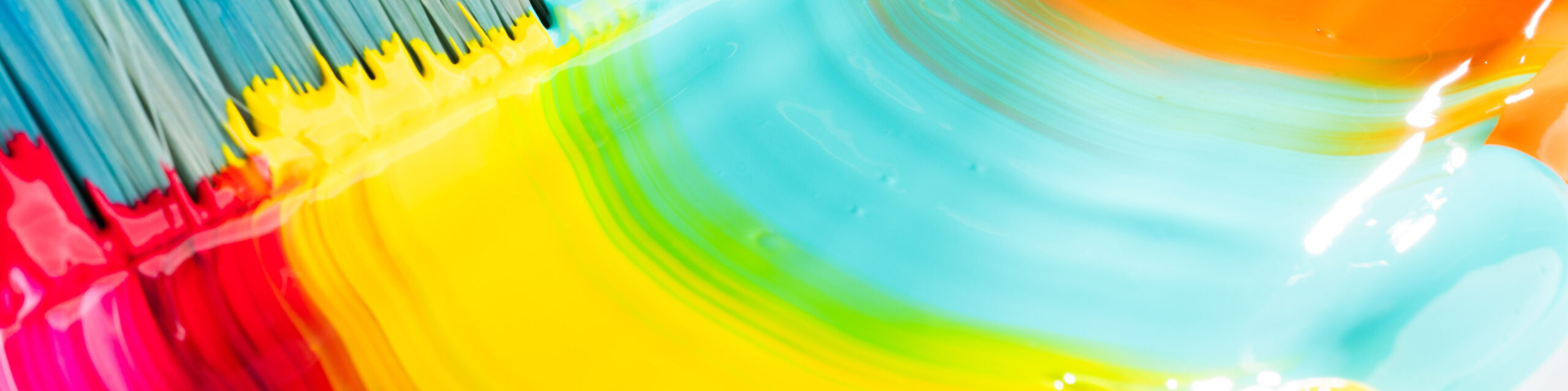 Nærbilde av flytende maling i sterke farger som blandes i buede strøk.