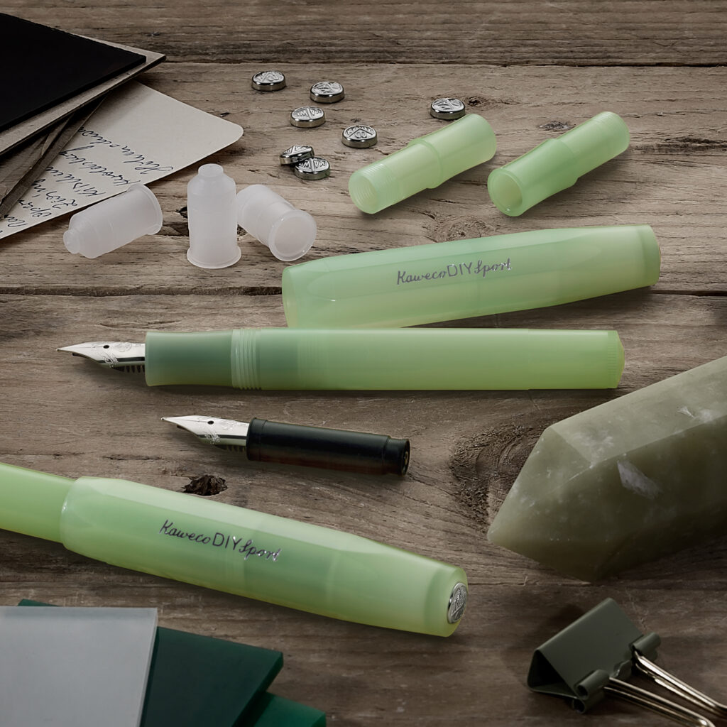 Lys grønn Kaweco DIY Sport fyllepenn med deler og patroner på trebord