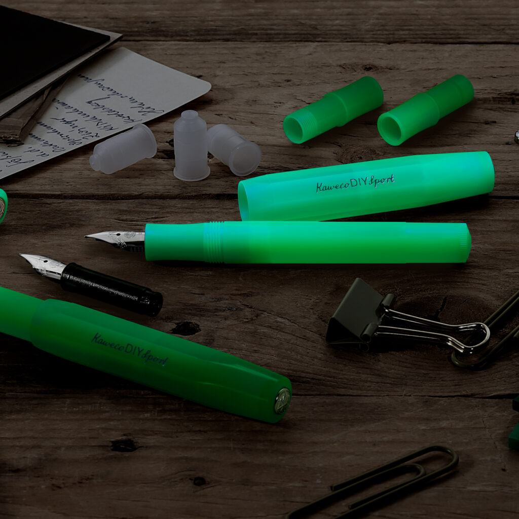 Grønn Kaweco DIY Sport fyllepenn med deler og patroner på trebord